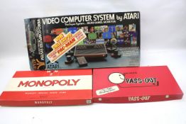 A boxed Atari computer system Monopoly and a Pass-Out boxed game.