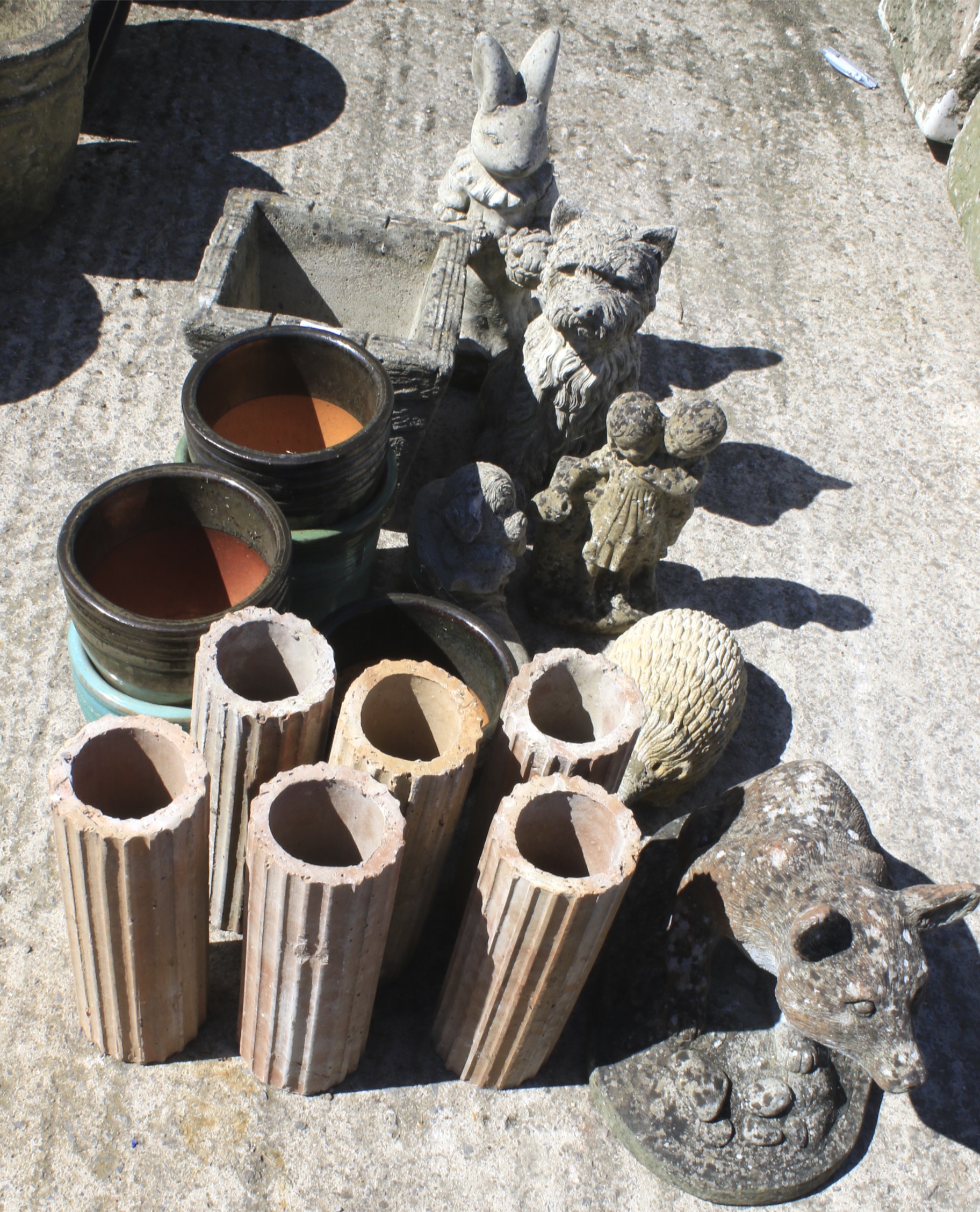 A collection of composite stone garden statues and pots.