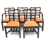A set of five stained wooden chairs.