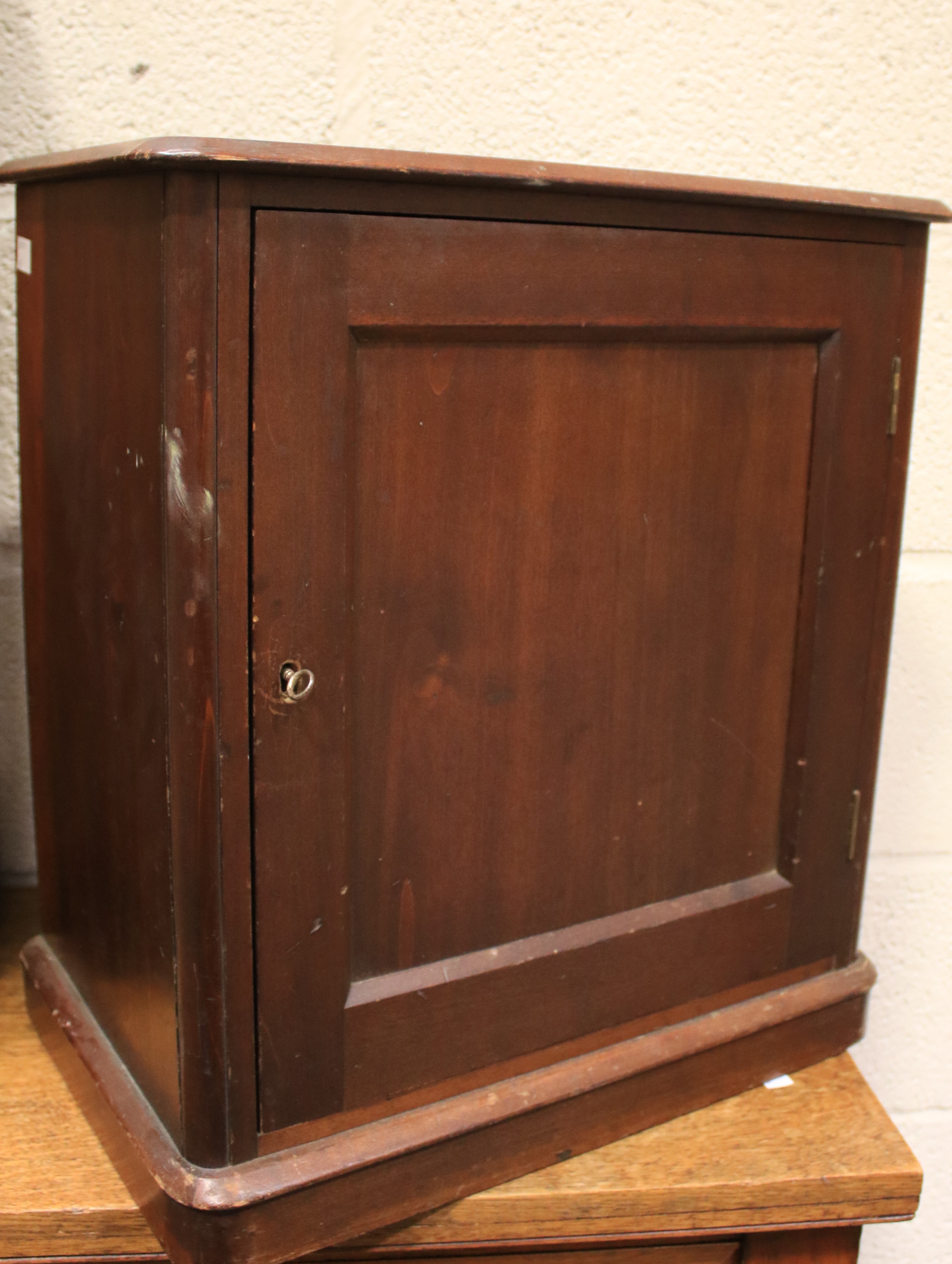 An Edwardian mahogany free standing smoker's cabinet. The single door enclosing a shelf and drawer.