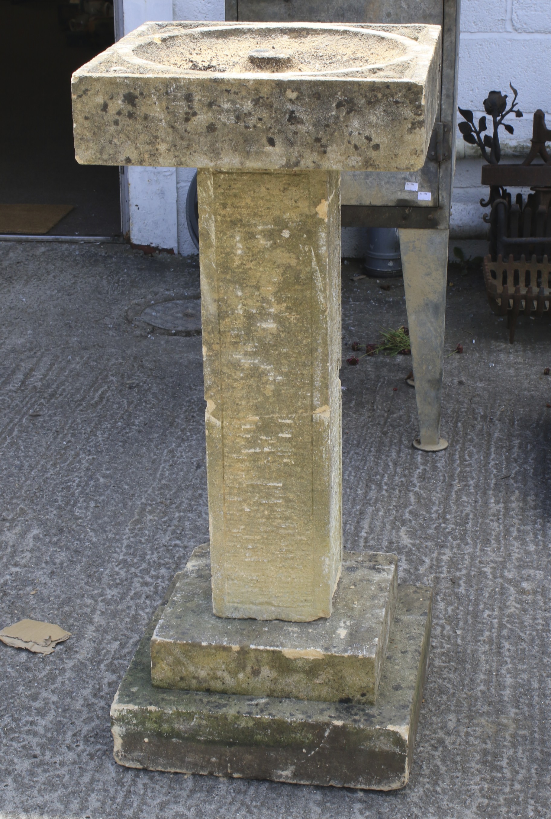 A sandstone bird bath, of square section.