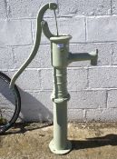 A large green painted cast iron water pump.