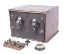 A WWII era oak cased morse code transmitter and receiver with related accessories.
