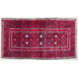 A Blooch red ground rug.