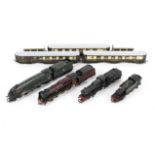 An assortment of OO gauge locomotives, tenders and coaches.