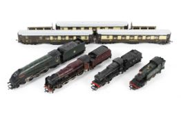 An assortment of OO gauge locomotives, tenders and coaches.