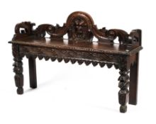 A heavily carved Jacobean style oak bench.