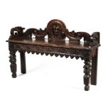 A heavily carved Jacobean style oak bench.