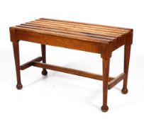 An oak Arts and Crafts style stool or luggage rack with slatted top.