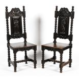A pair of early 20th century ebonised carved Jacobean style hall chairs.