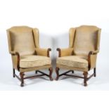 A pair of mid 20th century leatherette winged back elbow chairs with stud work decoration and