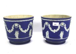 A pair of Wedgwood jardinairs. In blue and white, decorated with classical figures, H18.