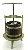A vintage green painted cast iron and slatted oak freestanding cider press.