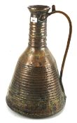 A Middle Eastern copper hand beaten flagon.