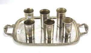 A set of six white metal beakers and a twin handled tray.