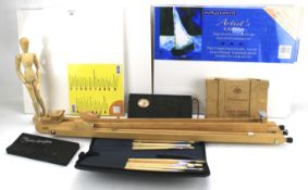 An assortment of artists' materials. Including a tabletop easel, canvases, books, etc.