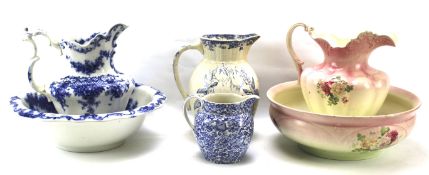 Two ceramic wash bowl and pitcher sets and two other pouring jugs.