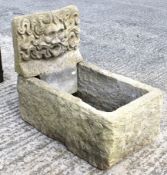 A 20th century composite stone planter trough and a water feature depicting the Green Man.