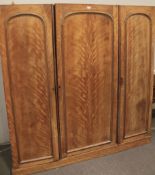 A large early 20th century wardrobe. WIth linen press, drawers and hanging space behind three doors.