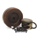 A 19th century wooden ship's pulley block, a belt wheel, and a trivet.