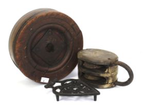 A 19th century wooden ship's pulley block, a belt wheel, and a trivet.