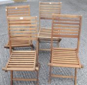 A set of four contemporary wooden folding garden chairs.