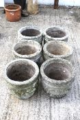 A set of six circular stone planters.