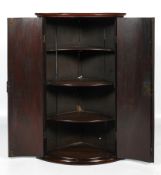 A 19th century mahogany bow fronted two-door wall hanging corner cupboard.