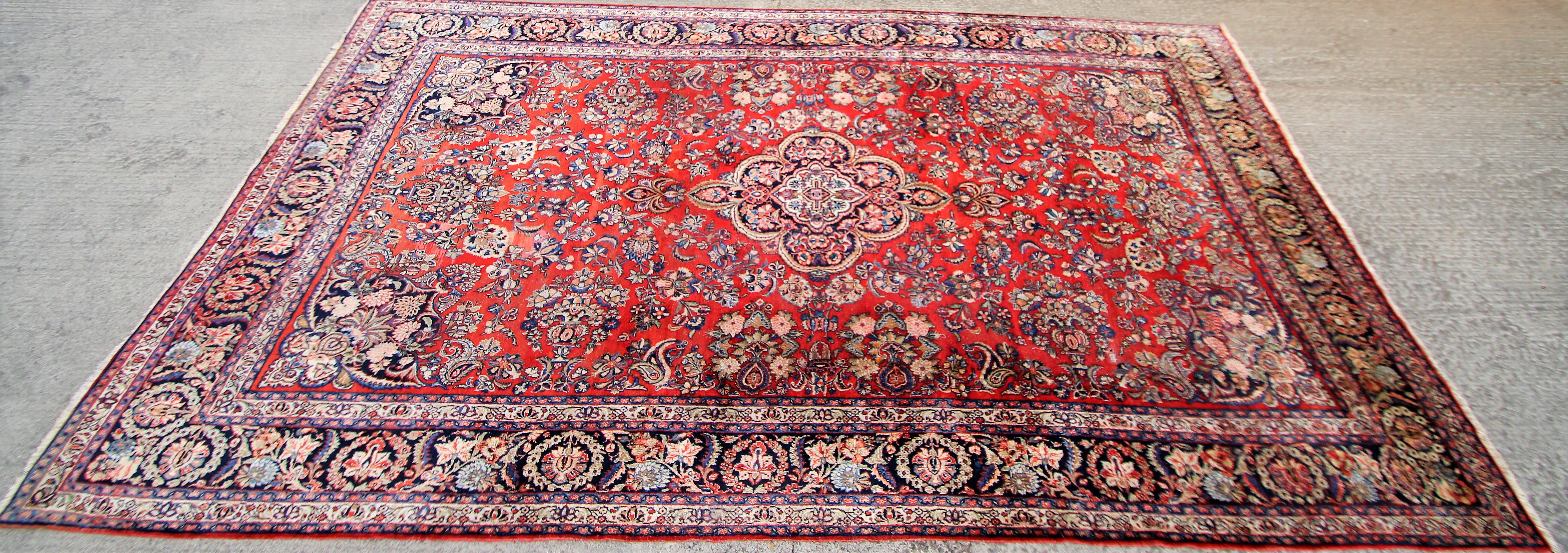 A 20th century wool Persian style carpet with central blue, brown and red medallion.