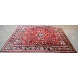 A 20th century wool Persian style carpet with central blue, brown and red medallion.