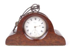A George V silver cased open faced Waltham pocket watch mounted in a wooden stand.