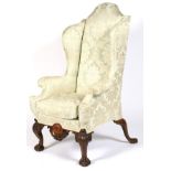 A 19th century upholstered wingback armchair.