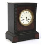 An ebonised wooden case mantle clock The enamel, face with Roman numerals,