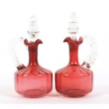 A pair of Victorian cranberry glass claret jugs and stoppers.