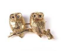 A vintage 9ct gold brooch in the form of two owls on a branch.