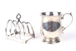 A silver christening mug & a four slice toast rack.