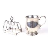 A silver christening mug & a four slice toast rack.