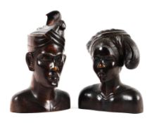 An early 20th century pair of carved hardwood busts of a Balinese man and woman.