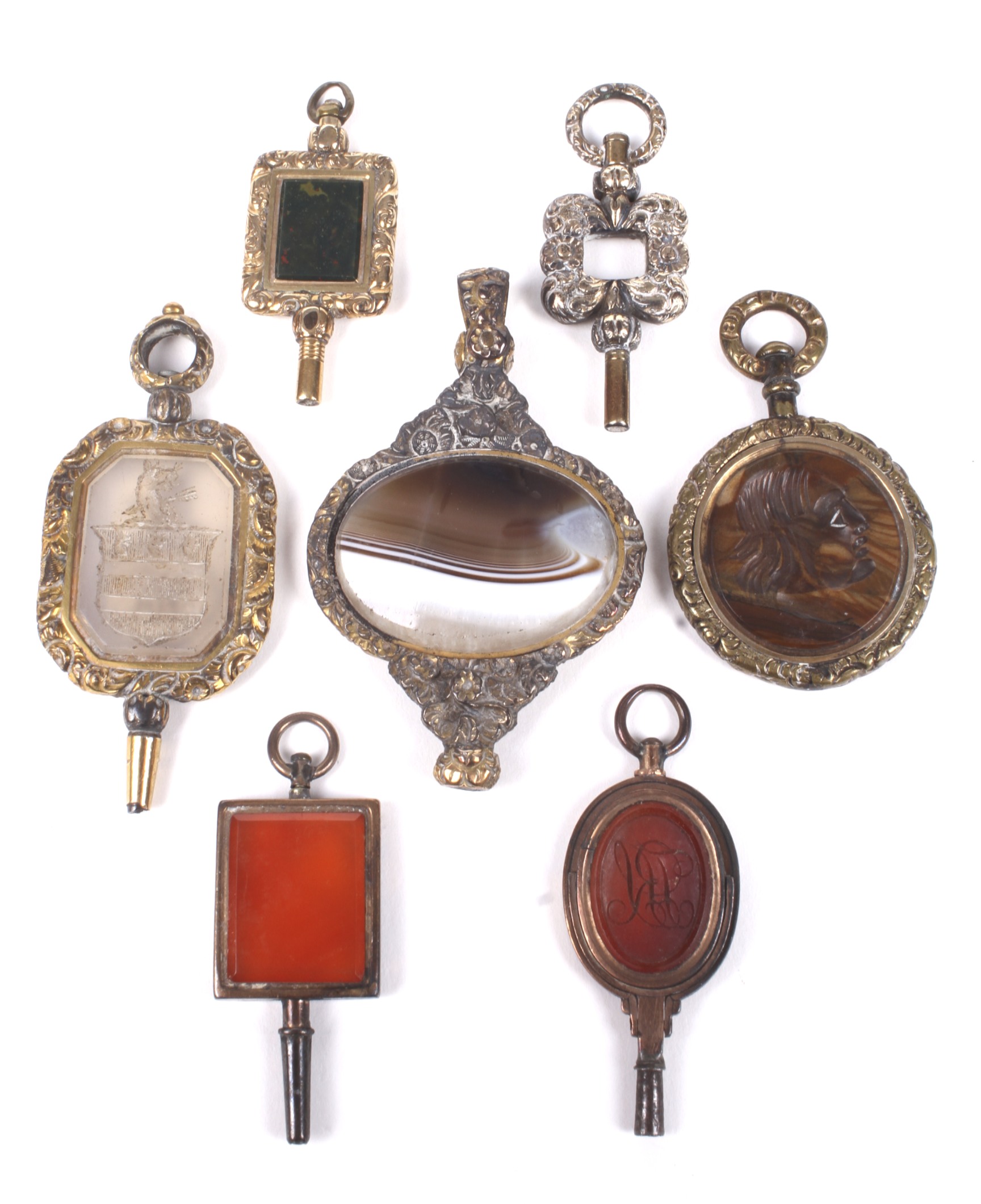 Six late George III and later hardstone set watch keys and another.