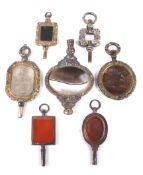 Six late George III and later hardstone set watch keys and another.