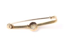 An early 20th century gold and opal single stone bar brooch.