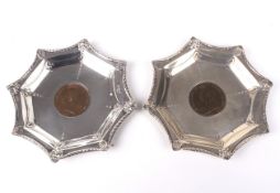 A pair of silver pin dishes with a 1901 & 1902 penny to the well.