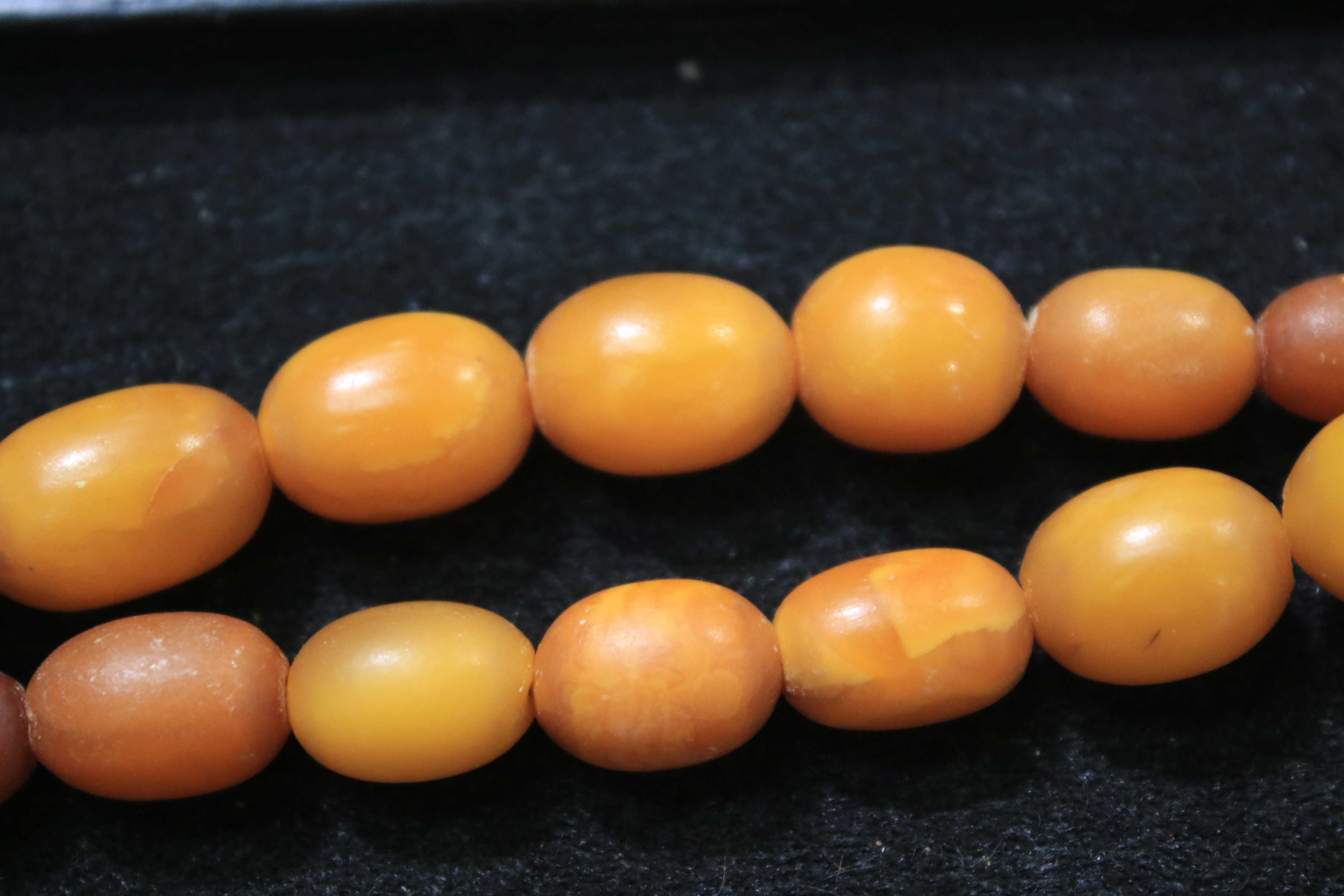 A amber oval bead necklace, the 46 varigated butterscotch-coloured oval beads - Image 5 of 14