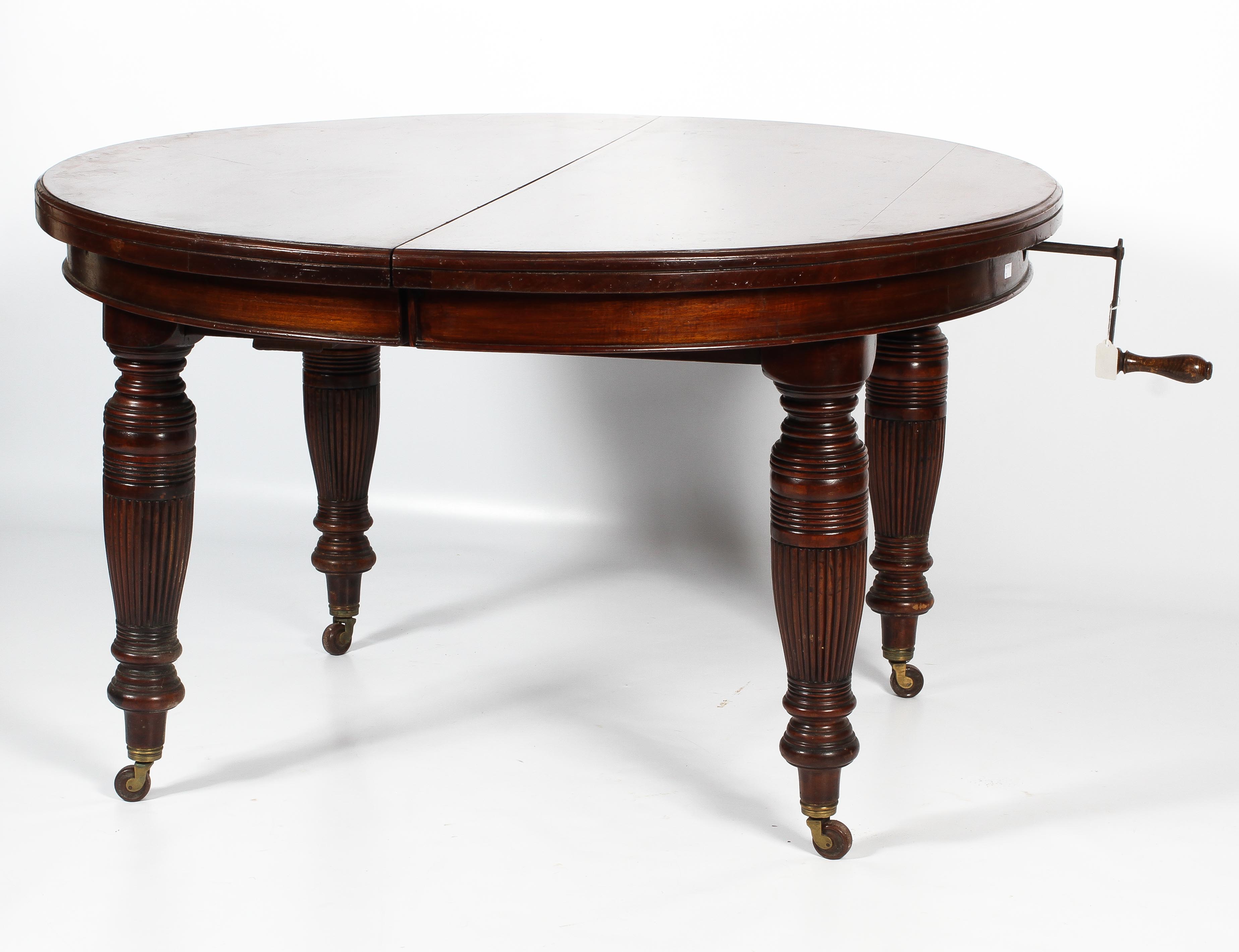 A Regency oval mahogany extending dining table.