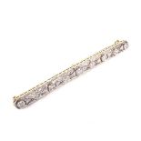 A mid 20th century gold and diamond open bar brooch in Art Deco style.