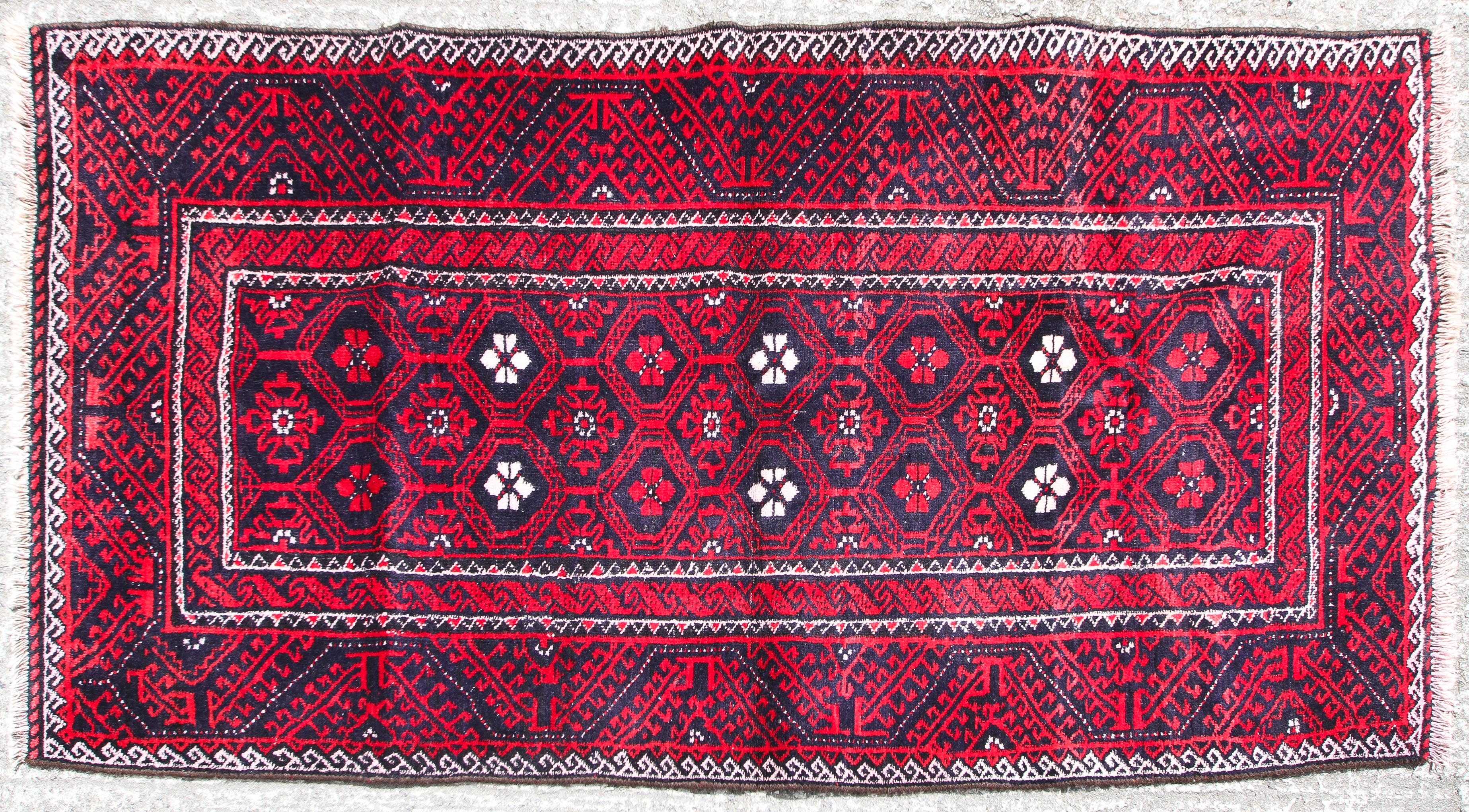 A Blooch red ground rug.