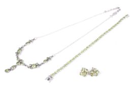 A silver and peridot bracelet together with a similar necklace and cluster earrings.