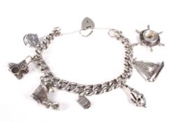 A white metal curb link charm bracelet on a padlock clasp stamped 'Silver'.