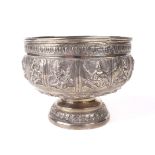 An Indian white metal embosed pedestal bowl.