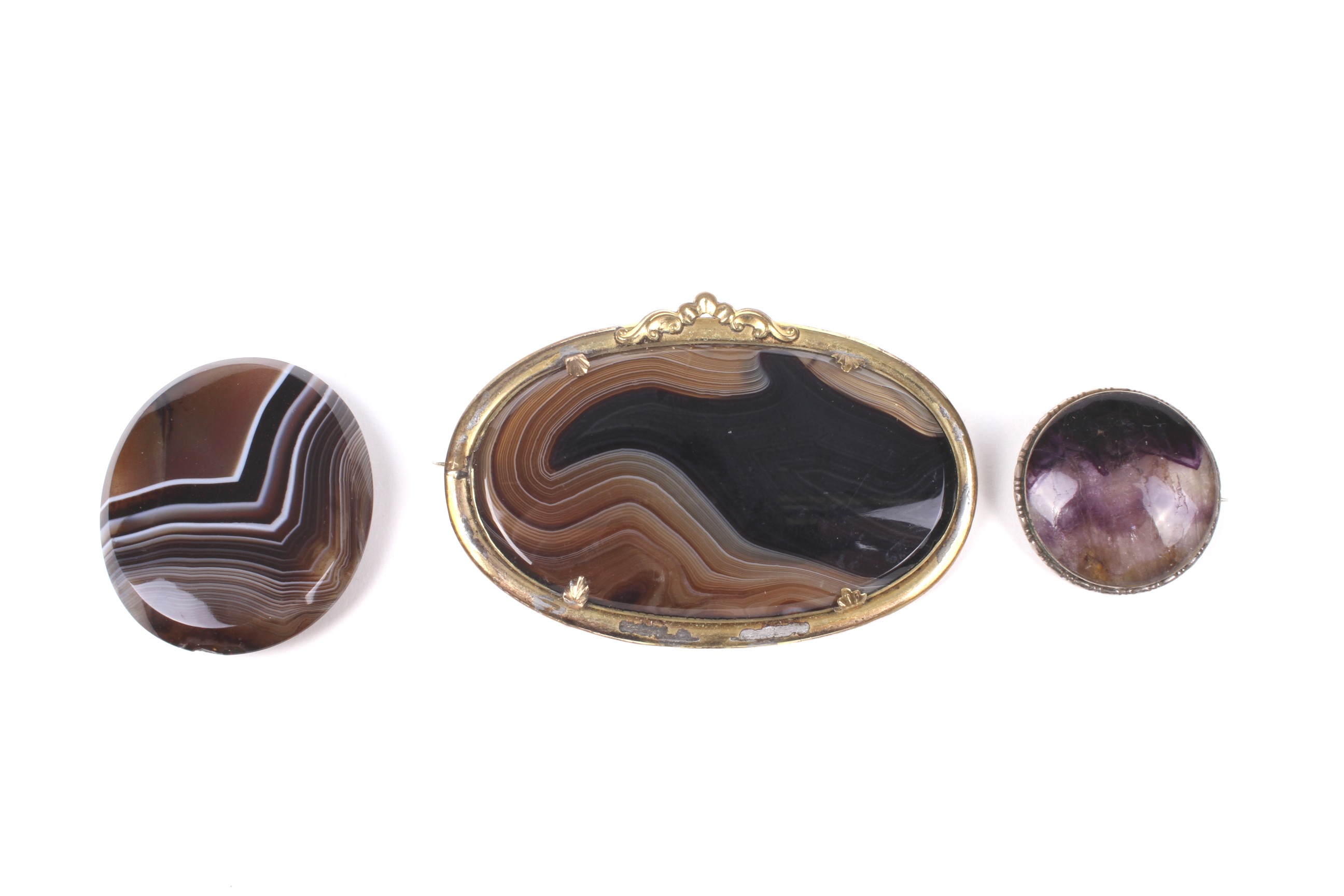 Two hardstone brooches and an oval agate panel.